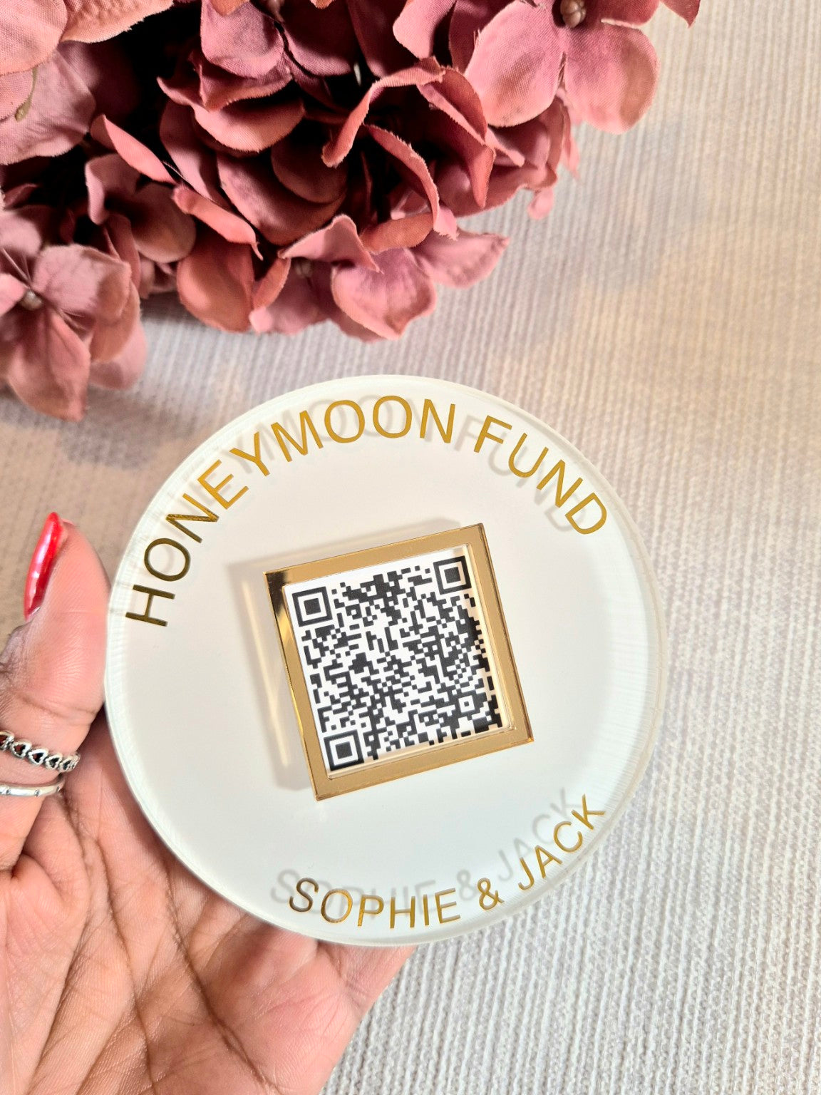 Personalised honeymoon fund QR code acrylic disc held in hand